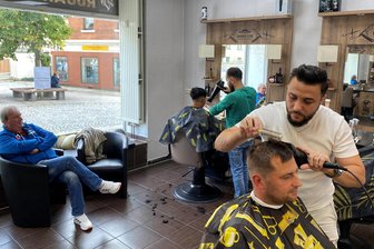 „Rugan Style“: Reichenbachs erster Barbershop kommt bei Männern an - und weckt Begehrlichkeiten - Das „Rugan Style“ an der Zwickauer Straße in Reichenbach. Dort, wo einst eine Shishabar firmierte, wird heute frisiert und rasiert. Moustafa Enetbawi frisiert Andreas Kuhn aus Neumark, dahinter Inhaber Mohamad Safou in Aktion.