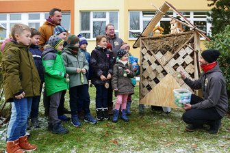 „Rund um Zschopau“: Wie ein Enduro-Verein den Insekten hilft - Im Beisein von Lehrer Jan Grieshammer und Vereinskollege Jens Horn stellt Micheal Keil (rechts), der Vorsitzende des MSC „Rund um Zschopau“ einigen Grundschülern das neue Insektenhotel vor.