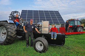 Russentreffen in Oberlungwitz: Fans alter Traktoren stehen auch auf moderne Technik - Markus Roscher im Renntraktor mit Thomas, Til und Christian Werner (v.l.) vor der neuen Fotovoltaik-Anlage in Bernsdorf.