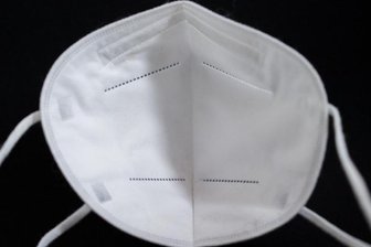            Eine FFP2-Maske liegt auf einem Tisch.