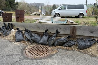Sachsenburg: Rathausstraße wird trockengelegt - Mit Verschalung und Sandsäcken gegen die Schlammfluten in der Rathausstraße.