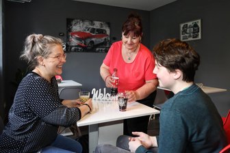 Sachsenring-Bistro in Zwickau eröffnet: Imbiss-Geschäft belebt ehemaligen Bäckerei-Laden neu - Im Sachsenring-Bistro in der Crimmitschauer Straße 67 a in Zwickau. Annette Knaissi serviert Getränke. Doren Schiffmann und Dean Schiffmann gehören zu den ersten Kunden des Tages.