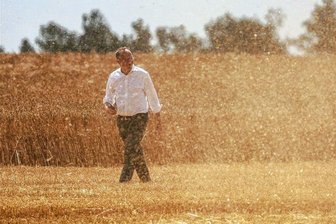 Sachsens Bauern stehen vor der teuersten Ernte aller Zeiten - Agrarminister Wolfram Günther geht bei Kitzscher durch Erntestaub über ein Feld mit Wintergerste. 