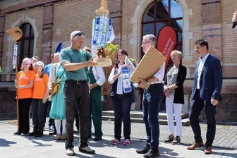 Sächsischer Wandertag: Der Staffelstab ist an Lugau übergeben - Nun ist Lugau dran: Matthias Berger (links), Oberbürgermeister von Grimma, übergibt den „Staffelstab“ mit Wimpeln vorangegangener Wandertage an Andreas Dietz, stellvertretender Bürgermeister von Lugau.