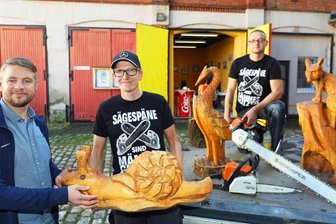 Sägespäne sind für Künstler Männerglitzer - Thomas Sprotte, Vorsitzender des Jugendclub-Fördervereins, mit den Kettensägen-Hobbykünstlern Jean-Philipp Russel und Michael Germuhl. Ihre Werke, meist Tierfiguren, sind zwischen 30 Zentimeter und zwei Meter groß.