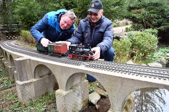 Saisonstart im Klein-Erzgebirge in Oederan: Von einem Miniatur-Bauwerk müssen sich Besucher verabschieden - Jörg Uhlig, links, und Achim Beyer positionieren die Gartenbahnen auf den Gleisen.