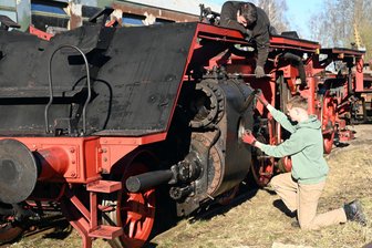 Saisonstart: Womit das Chemnitzer Eisenbahnmuseum in Hilbersdorf Fans 2025 anlocken will - Max Beier, vorn und Johnny Ullmann demontieren Kleinteile von der Museumsdampflok, die der Generaluntersuchung unterzogen wird.