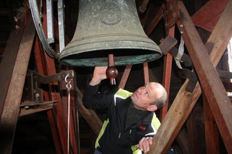 Sanierung der Kirchenglocken: Lauterbacher Gemeinde hofft auch auf Spenden - Jürgen Fritzsche vom Kirchenvorstand begutachtet die kleine Glocke der Lauterbacher Kirche.