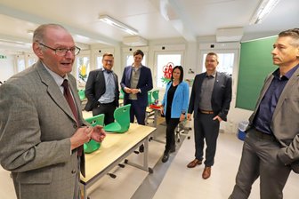 Sanierungsnotstand an Winkler-Schulen: Freiberg ist an der Kapazitätsgrenze - Reiner Hinz (l.), Leiter der Grundschule „Clemens Winkler“ in Freiberg, erläutert den Gästen die Funktionsweise der Schulcontainer.