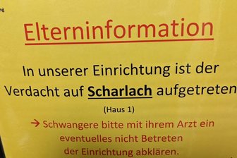 Scharlach in Mittelsachsen: Was steigende Fallzahlen mit Corona zu tun haben - Am Eingang einer Kita weist ein Schild auf einen möglichen Scharlach-Fall hin. In Sachsen treten vermehrt Scharlach-Infektionen auf. Vor allem Kita- und Grundschulkinder sind betroffen.