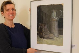 Schau erinnert an legendäre Mal- und Zeichenschule - Galerie-Mitarbeiterin Daniela Kolbe mit dem Bergbaustillleben von Karlheinz Walther, auf dem er 1958 seine später verschwundene Grubenlampe neben einem Schuh aus dem Schulfundus im Unterricht gemalt hat.