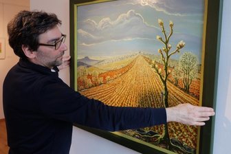 Schau widmet sich "seltenen Pflanzen" - Auf dem Foto präsentiert Galerieleiter Alexander Stoll ein Ölgemälde von Werner Franz