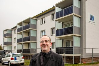 Schick und solide: Vermieter montiert in Augustusburg neue Balkone mit eingebauter Solaranlage - Balkonkraftwerke können auch schick aussehen: Der Geschäftsführer der Wohnungsverwaltungsgesellschaft Gemeindeverband Augustusburg vor dem Wohnhaus, an dem die neuen Balkone mit integrierten Mini-Photovoltaikanlagen montiert wurden.