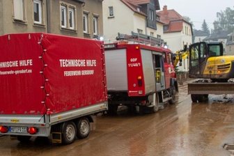 Schlammlawine im Sommerbad Gersdorf: "Der Schaden im Bad könnte in den Millionenbereich gehen" - Die wichtigsten Aufräumarbeiten dauerten seit den frühen Morgenstunden an. Straßen und Grundstücke sind nur noch schlammbraun.