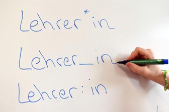 Schlechtere Noten fürs Gendern beim Schreiben: Wie Schüler und Lehrer auf Minister-Ankündigung in Sachsen reagieren - An einem Whiteboard steht das Wort "Lehrer" in verschiedenen Gender-Schreibweisen - was nun in Schüler-Aufsätzen in Sachsen als Fehler angestrichen und bewertet werden soll.
