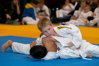 Schlettauer Judo-Kinder gewinnen sechs Titel, aber nicht den Pott - Marek Hofmann vom TSV Schlettau nimmt Fridolin Grahl vom JV Markneukirchen in eine Festhalte. Der Blondschopf aus den Reihen der Gastgeber wurde in seiner Gruppe Dritter während des Turniers um den 24. Räucherkerzenpokal.