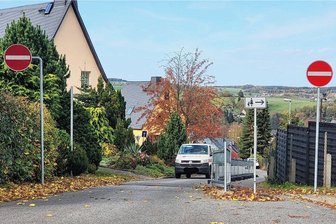 Schneeberg: Gericht verhandelt mitten auf der Fahrbahn - Die Engstelle auf der Eibenstocker Straße am Sommerberg. Autos dürfen nur bergaufwärts fahren. Der mit Bauzäunen abgesperrte Bereich soll laut Stadt ein Fußweg werden. Dieser wurde bisher nicht gebaut, weil der Rechtsstreit vor Gericht noch nicht entschieden ist. . 