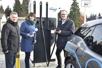 Schnelle E-Lade-Säule in Schöneck in Betrieb genommen - Nehmen die erste Schnellladesäule von Envia M in Schöneck in Betrieb: Bürgermeisterin Isa Suplie (CDU), Reginald Fuchs (rechts), Kommunalbetreuer Südwestsachsen der Envia M, und Michael Hecht, Geschäftsführer der DLT Schöneck.