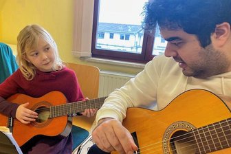 Schnuppertage der Musikschule Vogtland in Reichenbach und Auerbach sind voller Erfolg - Unterricht auf Augenhöhe. Musikschullehrer Erdem Karatas und Magdalena Schuster beim Erkunden der Gitarre.