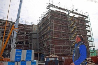 Schocken-Kaufhaus: So sieht die neue Stadtbibliothek aus - Mirko Große von der ortsansässigen Baufirma Voitel dirigiert per Fernbedienung den Baukran am ehemaligen Kaufhaus Schocken.