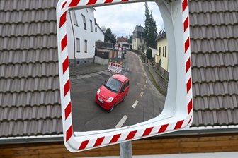 Schöne Bescherung in Taura: Warum keine Kita gebaut wird und die Kassen leer sind - Blick auf die gesperrte Hauptstraße im Oberdorf von Taura. Der Blick in den Verkehrsspiegel soll symbolisch dafür stehen wie auf eine Glaskugel: Bisher ist unklar, wie in den nächsten Jahren wichtige Vorhaben umgesetzt werden.