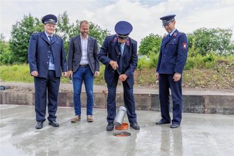 Schönfeld erhält neues Feuerwehrdepot: Grundsteinlegung für Millionen-Vorhaben - Der stellvertretende Wehrleiter Daniel Letzok, Bürgermeister Thomas Mey, Wehrleiter Jürgen Sprenger und der musikalische Leiter Toni Fiedler (v. l. n. r.) bei der Grundsteinlegung.