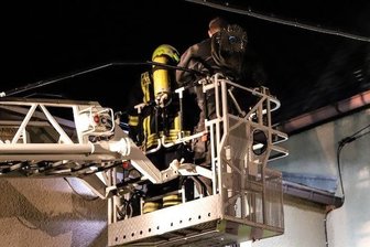 Schornsteinbrand in Albernau beschäftigt Feuerwehren über Stunden - Feuerwehrmann und Schornsteinfeger im Drehleiterkorb der Feuerwehr Aue, kurz vor der Reinigung des in Brand geratenen Schornsteins.