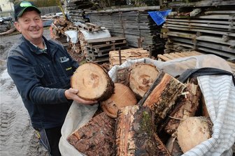 Schreiersgrüner Dorfverein sucht fleißige Hacker - Ralf Schneider mit den vorgeschnittenen Holzrollen für den Holzhack-Wettbewerb auf dem Weihnachtsmarkt Schreiersgrün.