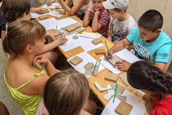 Schüler lernen Umgang mit Schnitzmessern - Nachdem die Vorlage auf Papier gezeichnet wurde, übertragen die Kinder die Konturen ihrer Schnitzarbeit auf Holz.