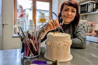 Schulanfang 2026: Bekommen Eltern im Erzgebirge jetzt noch eine Torte für den Kaffeetisch? - Konditormeisterin Miriam Kleditzsch alias „Miss Kuchenbäckerin“ verpasst einer ihrer Torten den letzten Schliff.