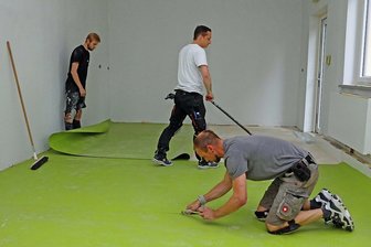 Schulen in Westsachsen: Wo Bauleute in den Ferien das Sagen haben - Die Fußbodenbauer Enrico Hauschild, Martin Schlegel und Max Masloff (von rechts) verlegen in einem Klassenzimmer der Grundschule in Frankenhausen einen neuen Fußbodenbelag.