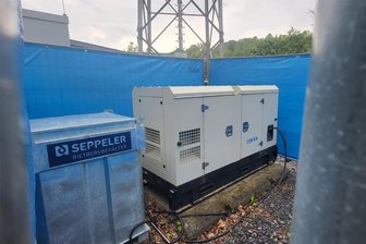 Schwarzenberg: Dieselgenerator am 5G-Mast muss bald nicht mehr als Netzersatzanlage dienen - Blick hinter die Absperrplane: Links der mobile Tank für das dieselbetriebene Stromaggregat am Mobilfunkmast.