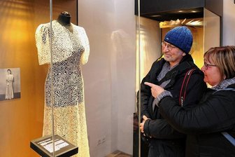 Schwarzenberg richtet 2024 den 40. Deutschen Klöppelkongress aus - Exponat in der Schatzkammer des Schwarzenberger Museums Perla Castrum und nur hinter Glas zu bewundern: ein um 1920 entstandenes, aus Klöppelspitze bestehendes Festkleid mit Bolero. Cornelia und Hans-Joachim Holm aus Burg Stargard (Mecklenburg-Vorpommern), als Touristen im Erzgebirge, zeigten sich beeindruckt. 