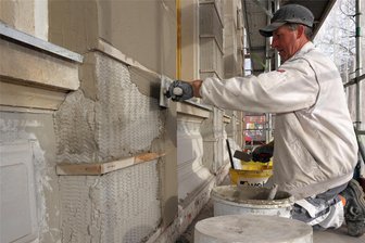 Schwarzenberg: Sanierung der Stadtschul-Fassade geht mit neuer Fachfirma auf Abschluss zu - Putzer Olaf Kämp von der SBC Fassadentechnik GmbH aus Crimmitschau bei Arbeiten an der Straßenfrontseite der Stadtschule Schwarzenberg. Bis zum Frühjahr 2024 soll die Fassadensanierung komplett abgeschlossen sein.