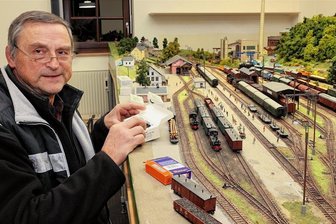 Schwarzenberger Weihnachtsmarkt: Modelleisenbahnen sind startbereit - Reinhardt Pester vom Schwarzenberger Modelleisenbahn-Club bei letzten Vorbereitungen an der H-0-Clubanlage "Bahnhof Grünstädtel". Sie spiegelt den dortigen Betrieb in der Zeit etwa Mitte der 1960er-Jahre wider.