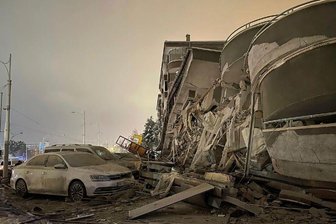 Beschädigte Fahrzeuge vor einem eingestürzten Gebäude in Diyarbakir.