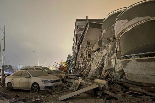 Beschädigte Fahrzeuge vor einem eingestürzten Gebäude in Diyarbakir.