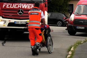 Schwerer Brand im Erzgebirge: 30 geistig behinderte Menschen und Pfleger gerettet – Notunterkunft in Kindertagesstätte - Ein Retter bringt einen Schwerbehinderten in Sicherheit: Bei dem Brand in Annaberg-Buchholz bei der Lebenshilfe gab es glücklicherweise keine Verletzten.