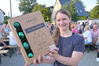 Schwibbogen-Anschieben im Erzgebirge: Niederdorf hat jetzt eine Eierlikör-Königin - Nadja Fritzsch ist zur Niederdorfer Eierlikör-Königin gekürt worden und freut sich über die Niederdorfer Christbaumkugeln.