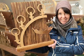 Stollbergs Marktmeisterin Bärbel Raatz zeigt den Pokal für den Schwibbogen-König.