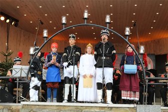 Schwibbogenfest im Erzgebirge: Bergstadt feiert ihre Tradition - Beim Schwibbogenfest in Johanngeorgenstadt werden die Figuren des Paula-Jordan-Bogens lebendig und erzählen ihre Geschichte, darunter auch Bergleute.