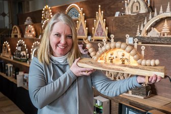 Schwibbogenschau in Stollberg: Von Lego bis Ozzy Osbourne - Marktmeisterin Bärbel Raatz mit einem Schwibbogen in Form einer Raupe, den sie als Dankeschön für die Organisation von einem Teilnehmer vergangenes Jahr geschenkt bekommen hat.