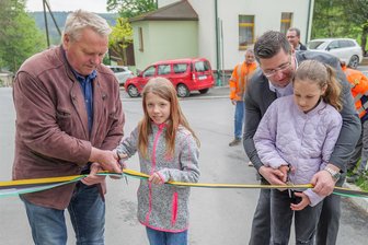 Sechs Jahre nach dem Schaden: Ortsdurchfahrt Hundsgrün wieder frei - Mit den Jüngsten durchschnitten Bürgermeister Stephan Meinel und Landrat Thomas Hennig (rechts) das Weiheband.
