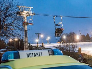 Sechsjährige bei Sturz aus Sessellift schwer verletzt - Ein Notarzt-Wagen steht an einem Sessellift.