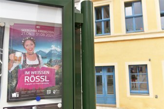 Seebühne Kriebstein: Das „Weiße Rössl“ nimmt Gestalt an - Vorfreude auf das „Weiße Rössl“ auf der Seebühne Kriebstein, Susanne Engelhardt gibt wieder die Wirtin Josepha Vogelhuber. Hier ein Plakat im Schaukasten vor dem Freiberger Theater.