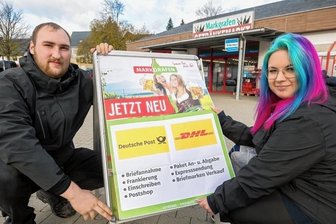 Seiffener kämpfen um ihre Post: Lösung in Sicht - Im Getränkemarkt befindet sich demnächst eine Postagentur: Marktleiter Lukas Seerig und Mitarbeiterin Emily Elster (v. l.) bestücken einen Werbeaufsteller in Seiffen mit einem Hinweisplakat.