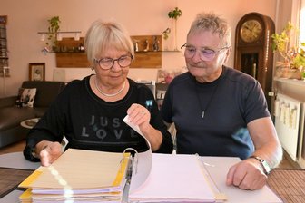 Seit 1981 in einer Zwickauer Genossenschaftswohnung: Warum Heidrun und Roland Förster nicht umziehen möchten - Heidrun und Roland Förster blättern durch den Ordner in dem die Beitrittserklärung zur Genossenschaft abgeheftet ist.