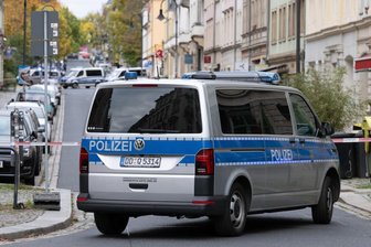 Ein Polizeiauto steht vor einem Absperrband im Dresdner Stadtteil Leipziger Vorstadt auf der Rudolf-Leonhard-Straße.