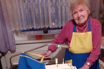 Seniorin näht Schürzen für die Ukraine - Irene Maliske näht in gelb-blau.