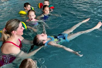 Sicheres Schwimmenlernen im Erzgebirge: Wo Kinder Angst vor dem Wasser überwinden - Katrin Helmrich inmitten ihrer Schwimmschüler. Die Sportwissenschaftlerin hilft den Kindern am Anfang, Vertrauen zum Wasser aufzubauen.